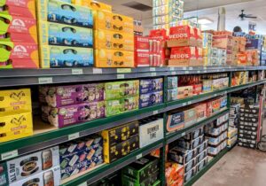 The aisles of a grocery store are full of beer.